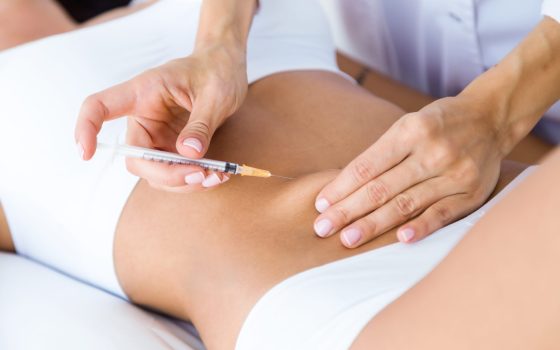 surgeon making injection into female body liposuction concept