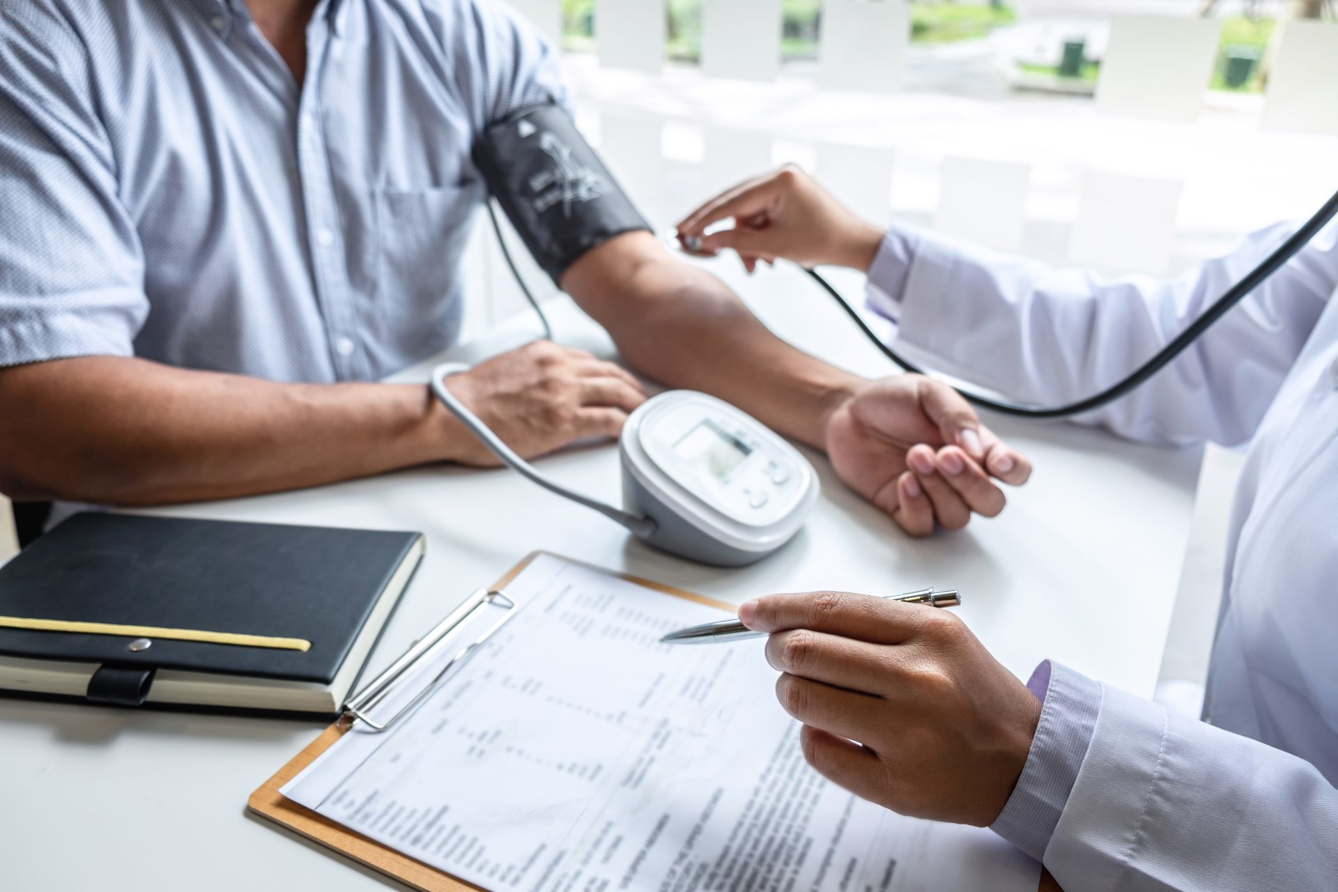 doctor using stethoscope checking measuring arterial blood pressure arm patient hospital